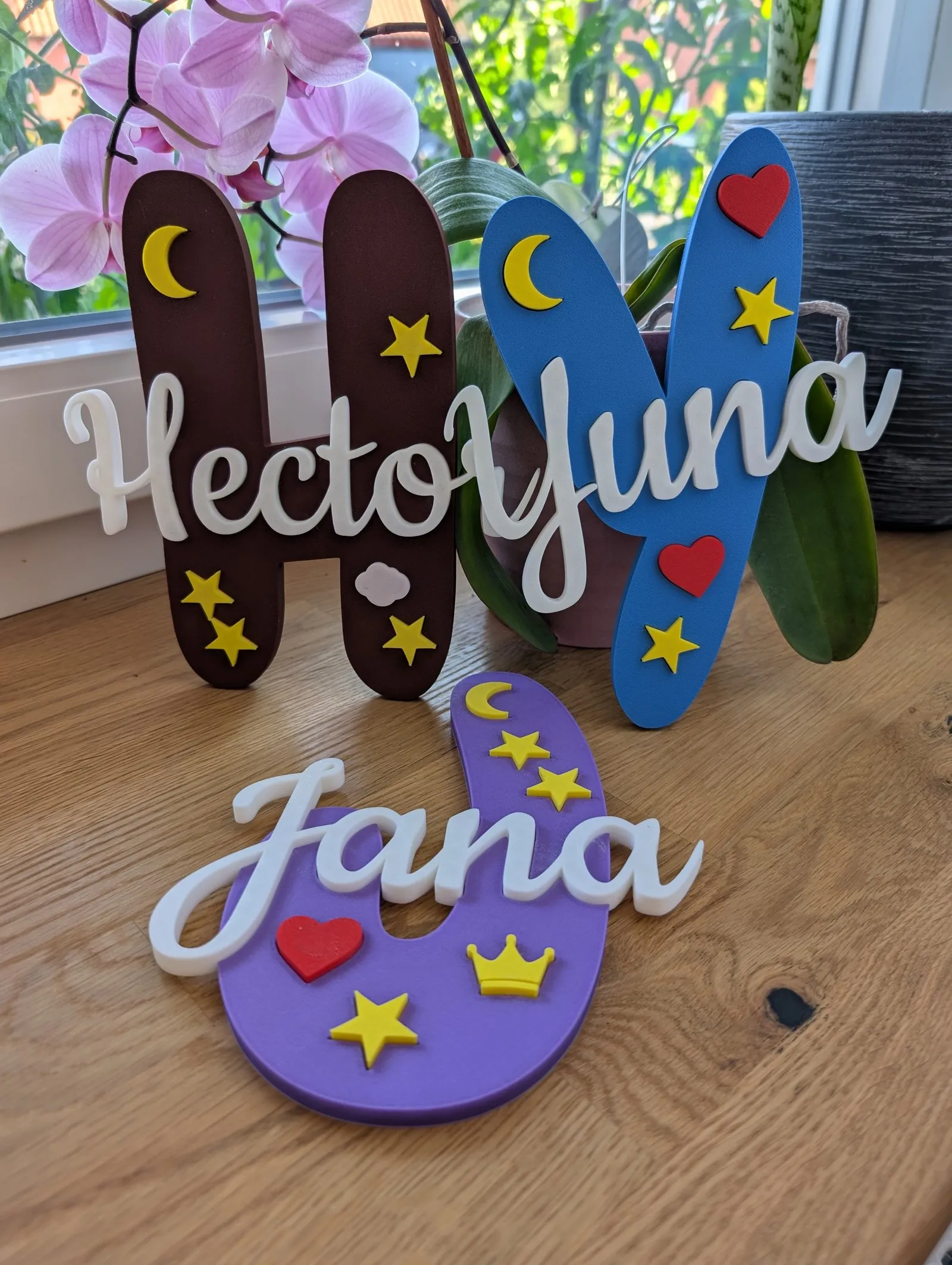 Drei Buchstaben-Türschilder mit den Namen 'Hector', 'Yuna' und 'Jana' in unterschiedlichen Farben